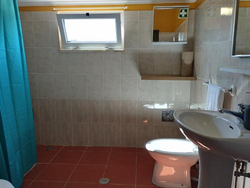 a bathroom with a sink and a toilet and a window at Monte Sol Nascente (Loft) in Grândola