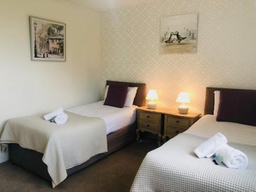 a hotel room with two beds and two lamps on tables at Newly renovated Old bakery House in Bath, 3 Bedroom, FREE Parking in Bath