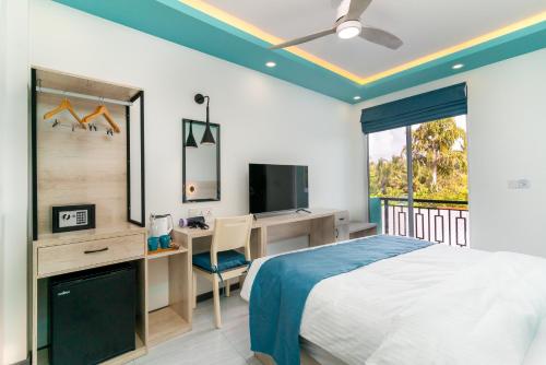 烏庫哈斯的住宿－Ukulhas Sands，一间卧室配有一张床、一张书桌和一台电视。