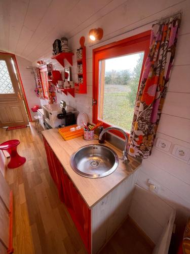 a kitchen with a sink in a tiny house at Roulotte Seventies in Orbec-en-Auge
