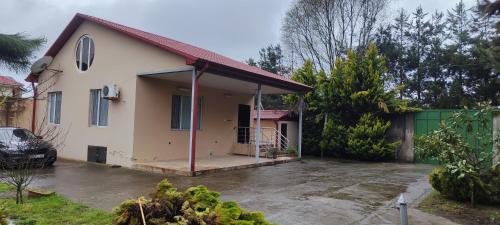 a house with a car parked in front of it at Pink house in Lankaran