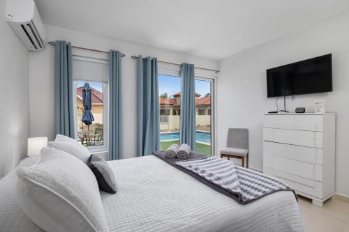 1 dormitorio con cama y ventana grande en Adele's Apartment with Pool, 5 minutes walk to the beach, en Palm-Eagle Beach