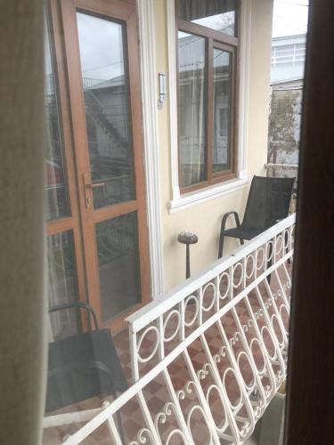 a balcony with two chairs and a wooden door at Vaxo hause in K'obulet'i