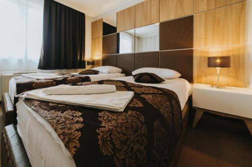 a hotel room with two beds with towels on them at Hotel Brcko Gas Doboj in Doboj