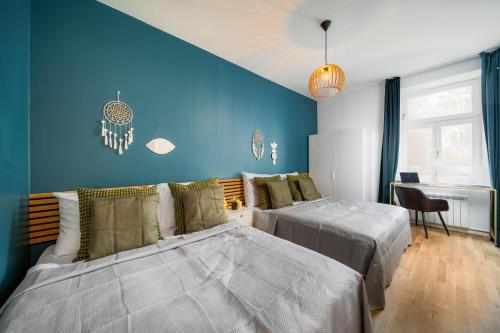 1 dormitorio con 2 camas y pared azul en Cavallo Business Apartments, en Praga