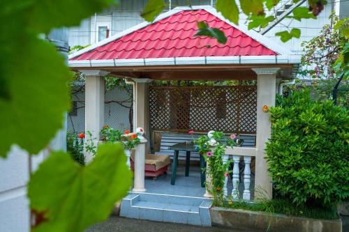 a gazebo with a bench and a red roof at Vaxo hause in K'obulet'i