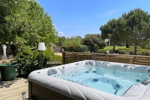 une baignoire jacuzzi assise sur une terrasse dans l'établissement Comfortable house with large garden and jacuzzi, à Rognes