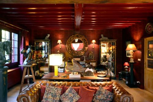 a living room with a leather couch and a mirror at Toute Une Histoire près de Fontainebleau in Veneux-les-Sablons
