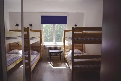 a room with three bunk beds and a window at Lövhults Vandrarhem in Nässjö