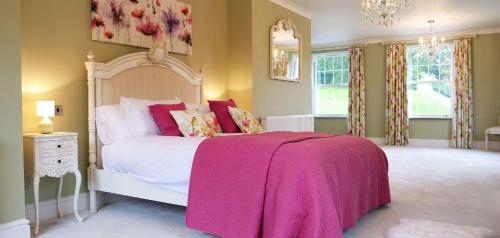 a bedroom with a white bed with a pink blanket at Wooladon House in Lifton
