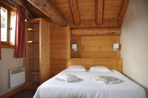 a bedroom with a white bed with wooden walls at Cortina - 52 - Appart lumineux - 8 pers in Les Deux Alpes