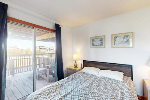 a bedroom with a bed and a balcony at Happy Place in Rodanthe