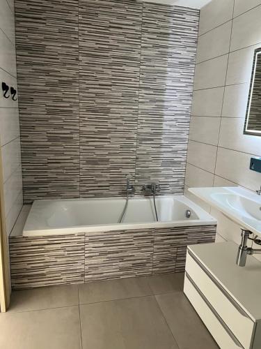 une salle de bain avec une baignoire et un lavabo dans l'établissement Bastia 2p neuf vue mer grande terrasse, à Bastia