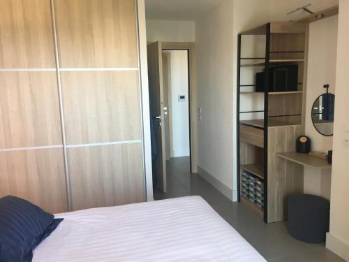 une chambre avec un lit et une étagère dans l'établissement Bastia 2p neuf vue mer grande terrasse, à Bastia