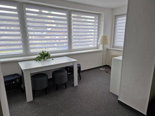 a room with a white table and a window with blinds at Hotel Harrachov Inn in Harrachov