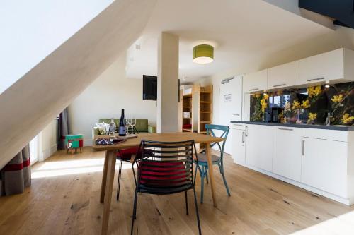 eine Küche und ein Esszimmer mit einem Holztisch und Stühlen in der Unterkunft Berghaus Freiburg - Appartement Hotel auf dem Schauinsland in Oberried