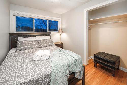 a bedroom with a bed with two white towels on it at A-Home by chinook mall and Heritage park in Calgary