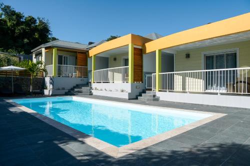 a house with a swimming pool in front of it at LE MALAYA in Saint-Joseph