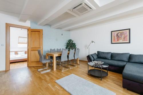 een woonkamer met een bank en een tafel bij Exclusive Apt Central loc 2bdr Old Town ELI in Praag