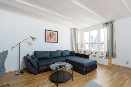 ein Wohnzimmer mit einem blauen Sofa und einem Tisch in der Unterkunft Exclusive Apt Central loc 2bdr Old Town ELI in Prag