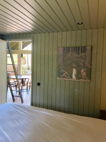 Kappelshamn的住宿－梅文海濱山林小屋，卧室配有一张床,墙上挂有绘画作品