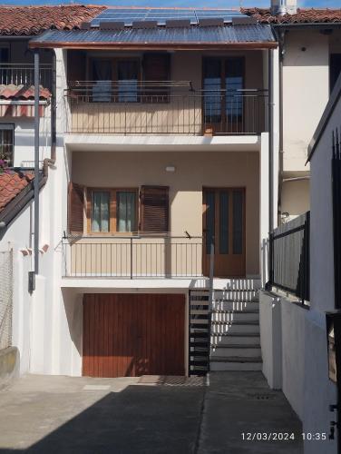 una grande casa bianca con balcone e scale di IL NIDO a Busca