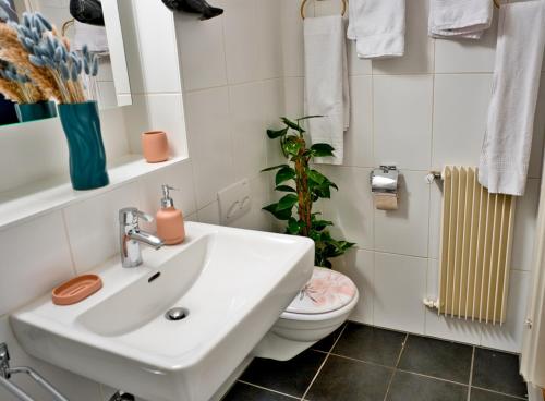 een badkamer met een witte wastafel en een toilet bij Studio 5 places à deux pas du Lac in Territet