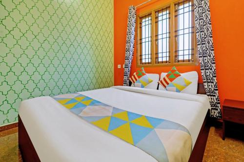 two beds in a room with orange walls at SAI BALAVANY RESIDENCY Pondicherry in Puducherry