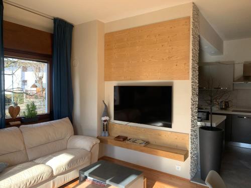 a living room with a large flat screen tv on a wall at Appartamento Carducci in Pieve di Cadore