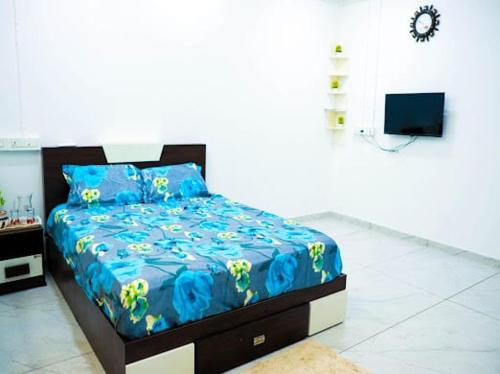 Aamees paradise في Kolitottattuturu: غرفة نوم بسرير وملاءات زرقاء وتلفزيون