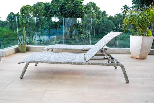 two chairs sitting on top of a balcony at Riverbank One Bedrooms Apartment, Swimming pool, gym, workspace, DB Space Living in Nairobi