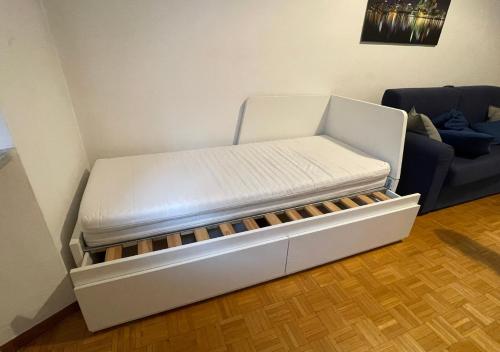 uma cama branca num quarto com um sofá em BnB Lodi em Turim