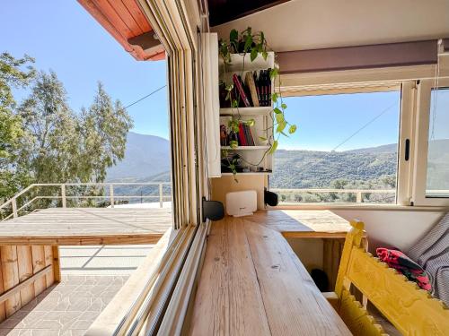 a room with a wooden table and a large window at Mountain Bliss Guesthouse 1 next to Sougia in Agrilés
