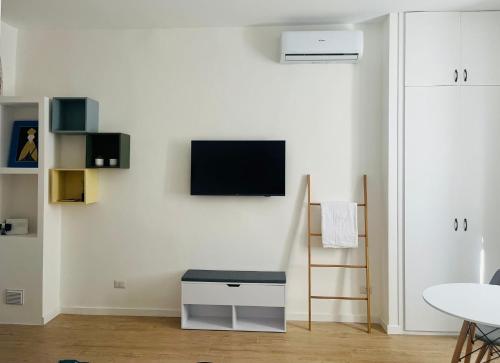 a living room with a tv on a white wall at Lomat Apartment in Milan