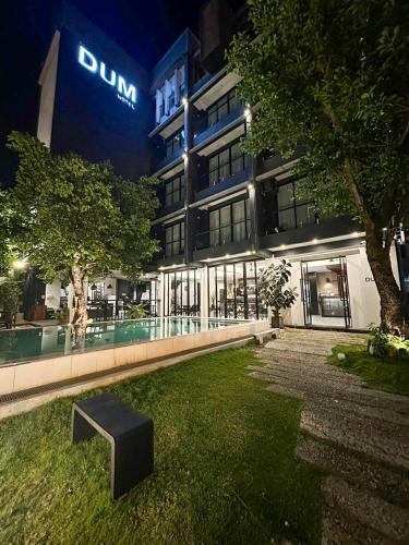 a building with a bench in front of it at night at DUM Hotel - Si Phum in Chiang Mai