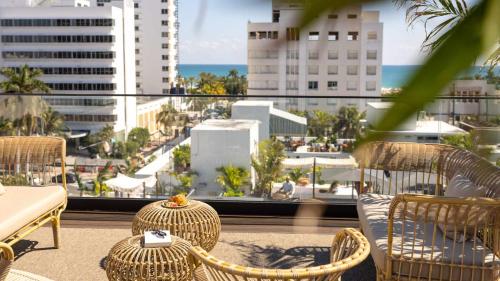 a balcony with wicker chairs and a view of the ocean at Uma House by Yurbban South Beach in Miami Beach