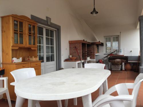 a kitchen with a white table and white chairs at Holiday home Monte das Azinheiras in Arraiolos