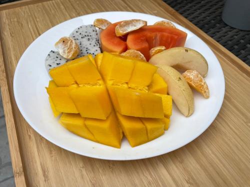 a plate of cheese and vegetables on a table at Central Old Town Cottage in Bangkok