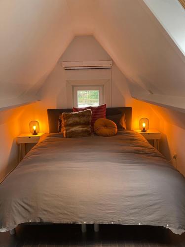 a bedroom with a large bed with two lights at Grote vakantiewoning nabij Brugge! in Damme