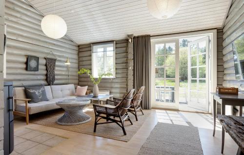 a living room with a couch and a table and chairs at 3 Bedroom Amazing Home In Sæby in Sæby