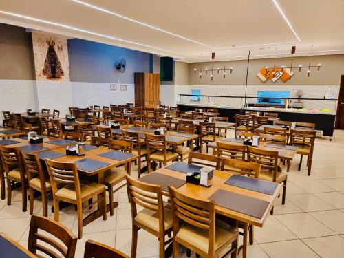 a dining room with tables and chairs in it at MAPP Hotel Aparecida-SP in Aparecida