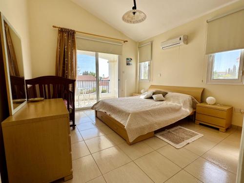 ein Schlafzimmer mit einem Bett und einem Balkon in der Unterkunft Cheerful 3 bdr villa near the beach in Coral Bay