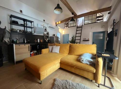 a living room with a yellow couch and a kitchen at Holiday Home Forest INN in Sveti Martin na Muri