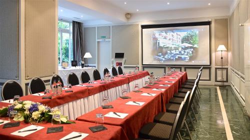 a row of tables in a room with a large screen at Carlton Lausanne Boutique Hôtel in Lausanne