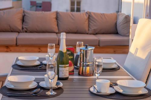 a table with a bottle of wine and glasses at Penthouse with Jacuzzi, and garaje Grupo AC Gestion in Cádiz