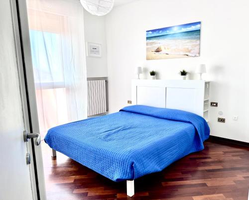a bedroom with a bed with a blue blanket at CASA ELENA- Casa Vacanze nel centro di Sottomarina in Chioggia