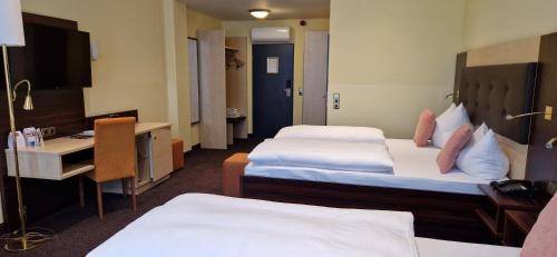 a hotel room with two beds and a desk at Best Western Hotel Augusta in Augsburg