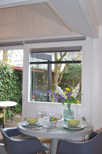 a table with a vase of flowers on it at Studio Clematis Bergen in Bergen