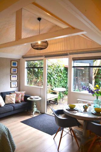 a living room with a couch and a table at Studio Clematis Bergen in Bergen