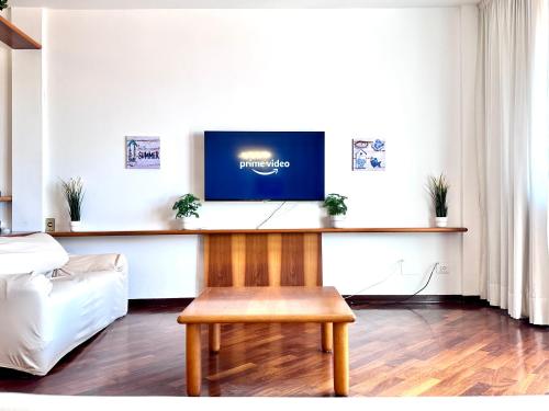 a living room with a tv on a wall at CASA ELENA- Casa Vacanze nel centro di Sottomarina in Chioggia